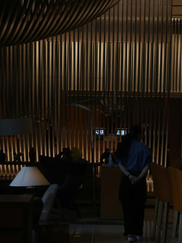 Hotel Security Supervisor Job Description: Free Template, Duties & Hiring Test 1 Hotel staff member standing in a dimly lit lobby