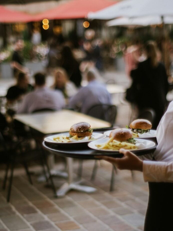 Waiter to Restaurant Captain: Career Path, Skills & Checklist 1 Waiter carrying plated food in restaurant service