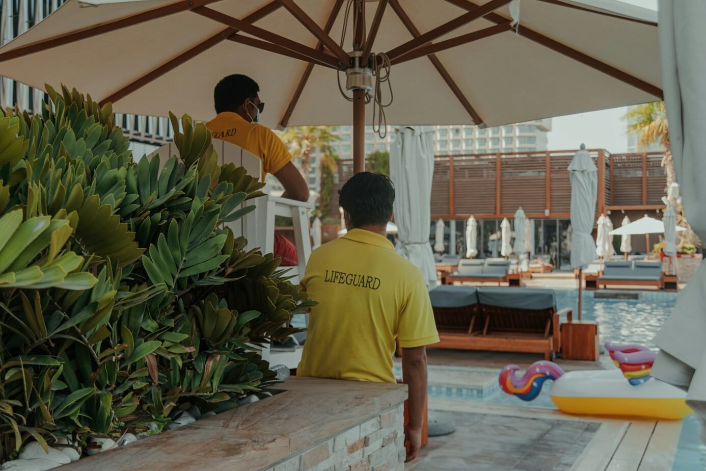 Hotel Lifeguard Job Description: Free Template, Duties & Hiring Test 1 Hotel lifeguard supervising swimmers near an outdoor resort swimming pool